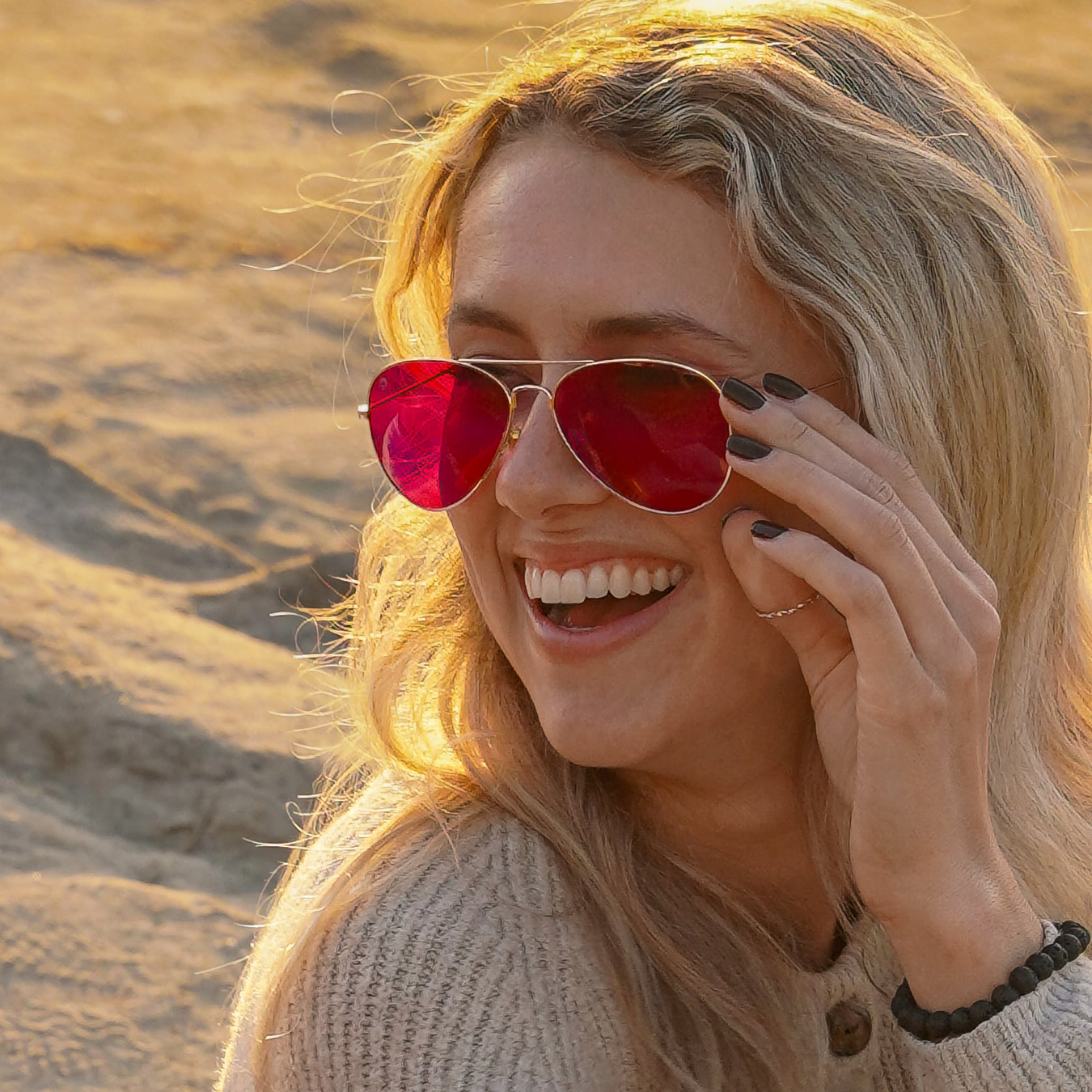 Woman wearing red-lensed sunglasses in a desert setting